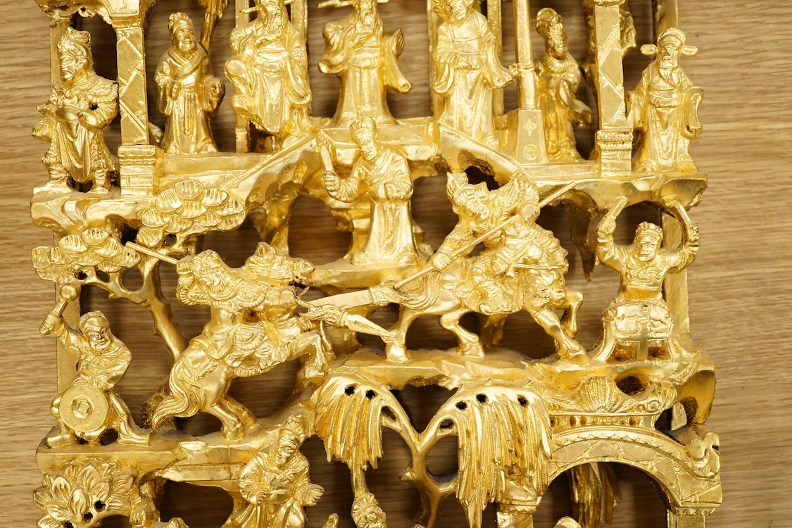 A Chinese carved gilt wood panel, depicting battle scenes, 50cm high